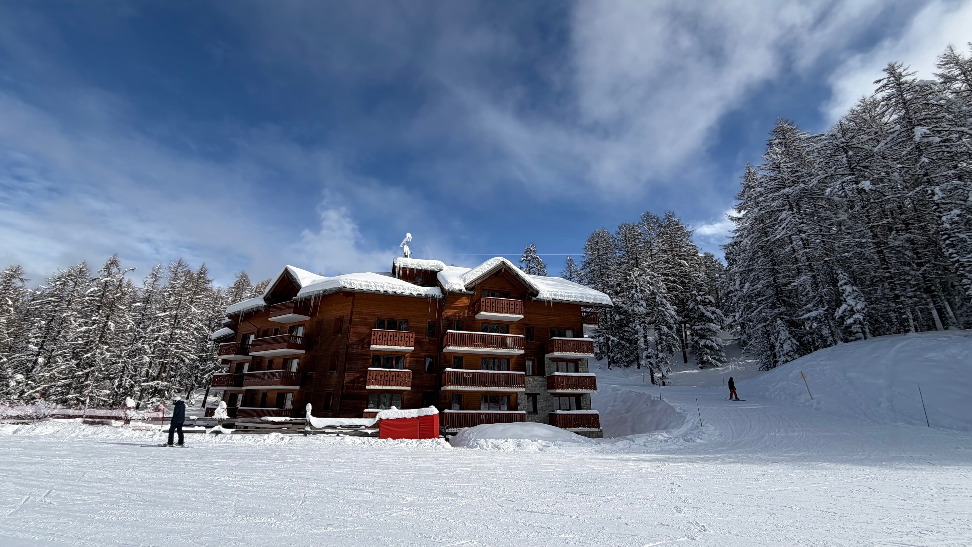 La résidence Albane sous la neige, au pied des pistes, entourée de mélèzes